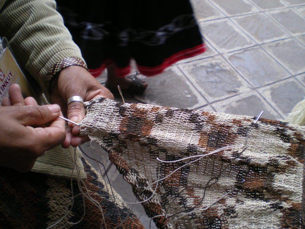 Mujer Wichi tejiendo una tela en anillado, obras de viajes de un pueblo nomada de Argentina